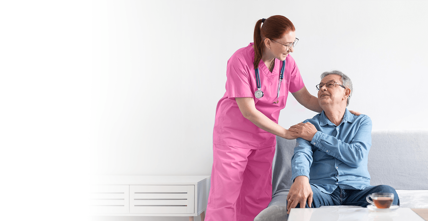 Young readhead caregiver touching older man on the shoulders